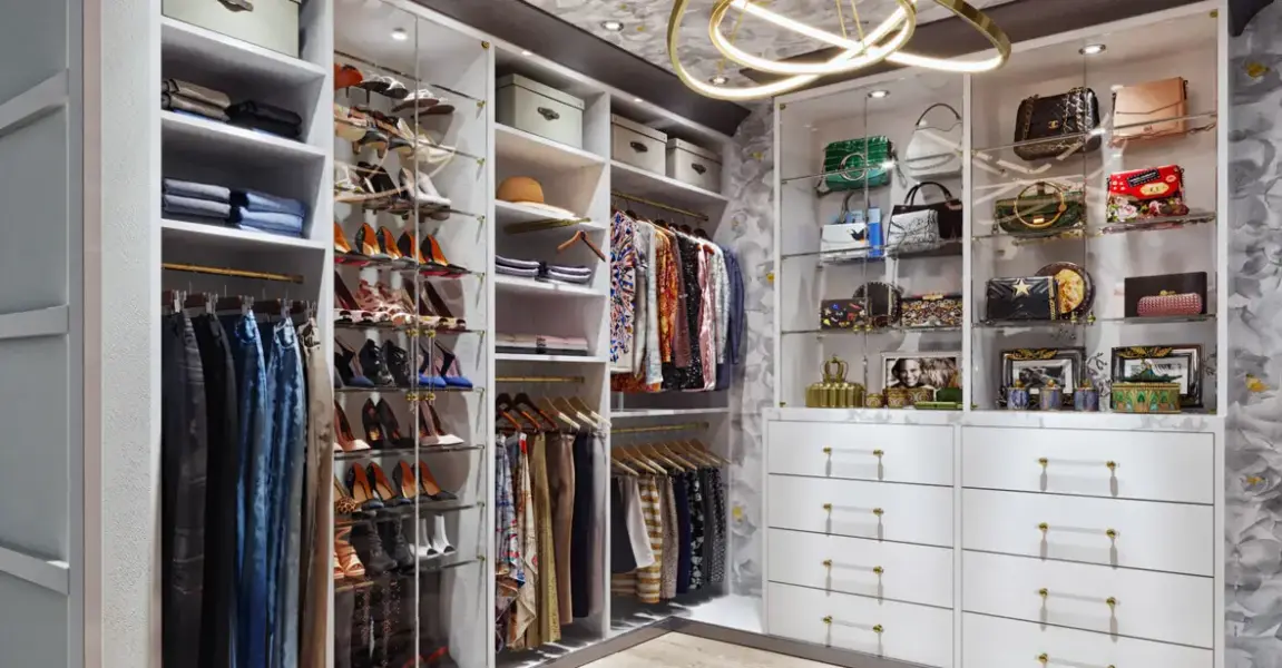 White walk-in closet with angled shoe shelving, glass-front drawers and hanging sections on three walls