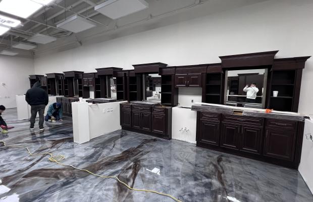 Installers setting espresso cabinet runs across a wide commercial room