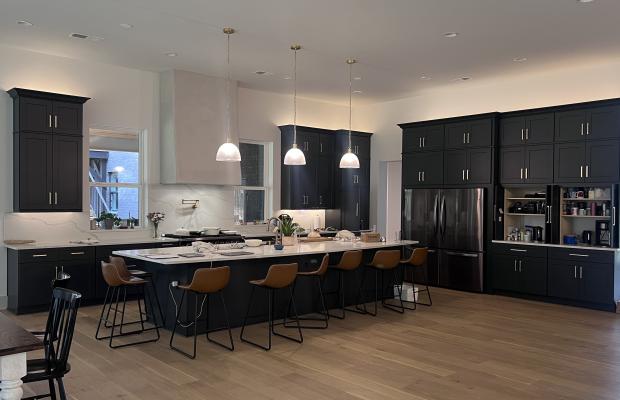 Open-plan charcoal shaker kitchen with a long island, bar seating and pendant lighting