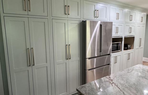 Tall painted pantry cabinets around a stainless refrigerator