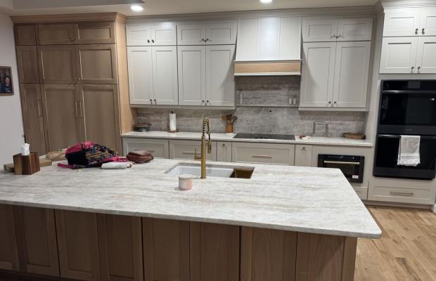 White shaker kitchen with a wood-trimmed hood, oak island and wall ovens