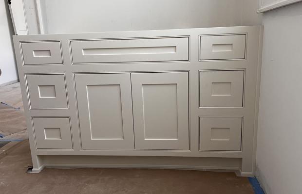 White vanity front with recessed panels and a full-width top drawer