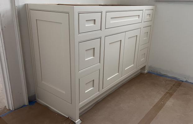 White vanity base cabinet levelled in place before the countertop is templated