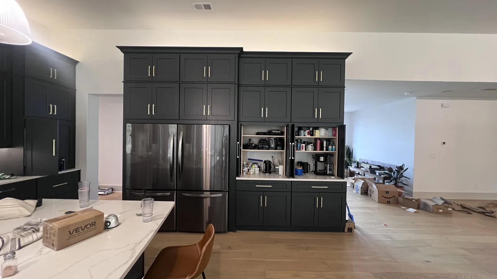 Full-height charcoal pantry wall around the refrigerator with the coffee station open