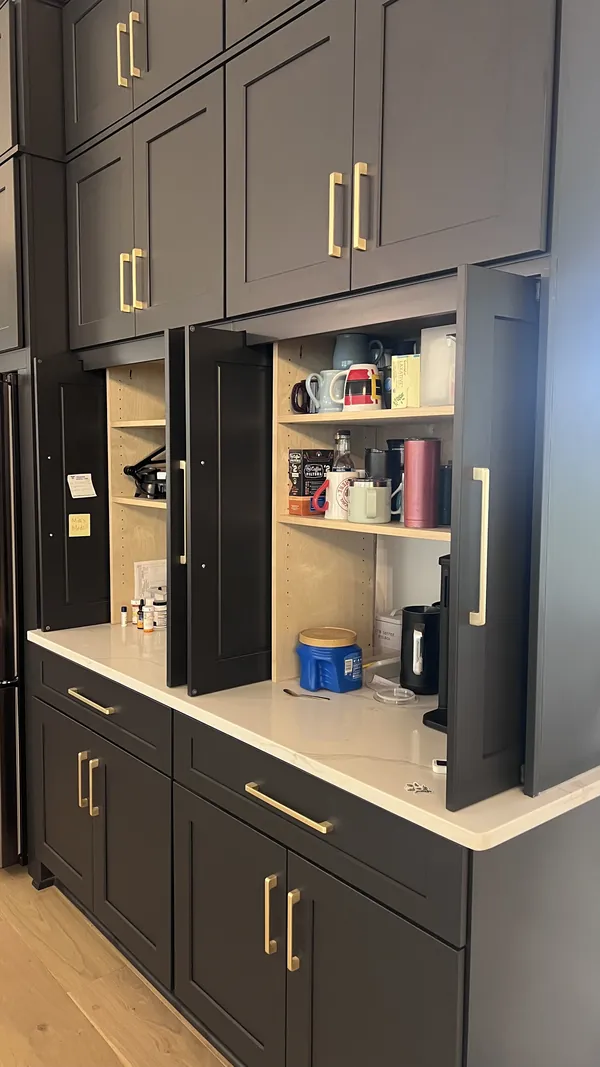 Pocket-door pantry cabinet open, with shelves above a counter