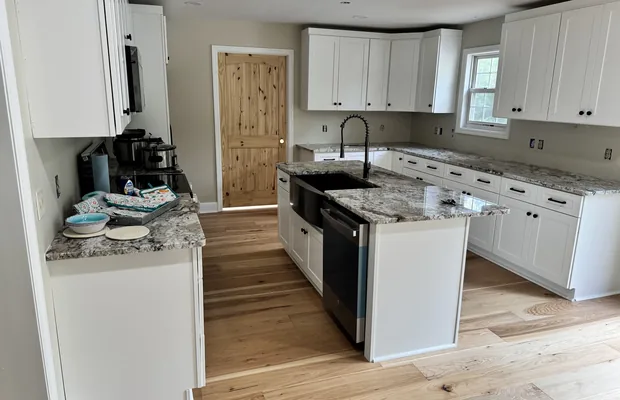 White shaker kitchen with a speckled stone countertop and island